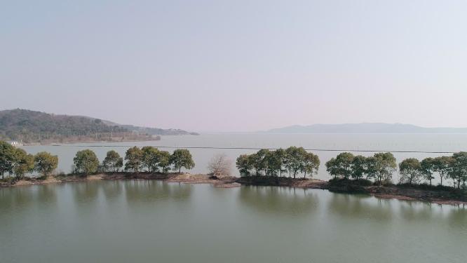 4K航拍，晴朗的天气，春天的太湖湖面和湖边的绿色的树木的风景