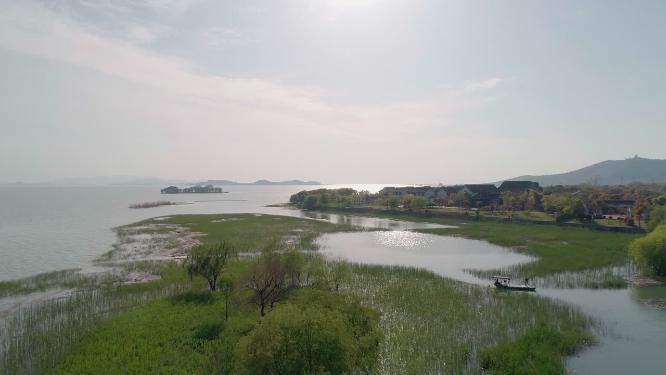4k航拍，苏州太湖边。沿太湖大道，蓝天白云绿树掩映下的湖边别墅、酒店及公共建筑