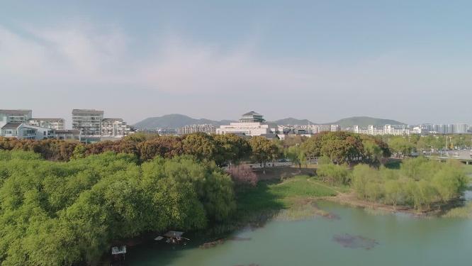 4k航拍，苏州太湖边。沿太湖大道，蓝天白云绿树掩映下的湖边别墅、酒店及公共建筑