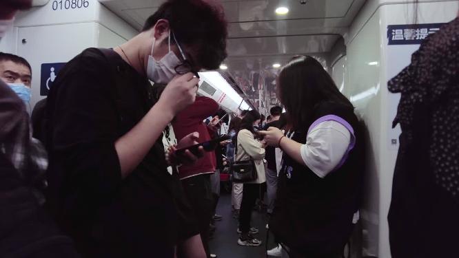 坐地铁玩手机的乘客