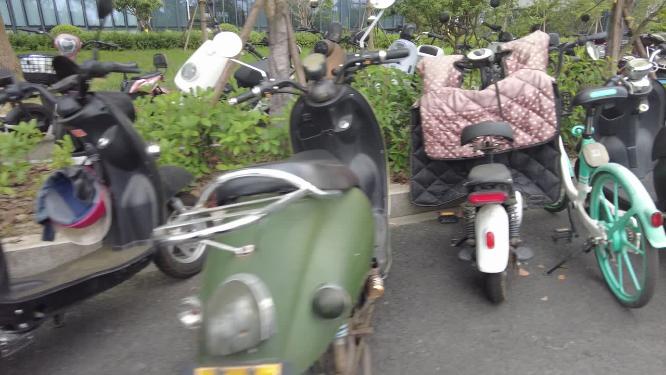 马路旁整齐停放的电动车和共享单车