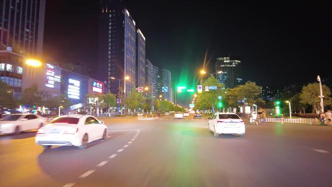 城市夜晚马路上面行驶的汽车