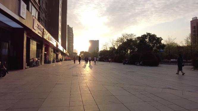 城市夕阳下的路人散步