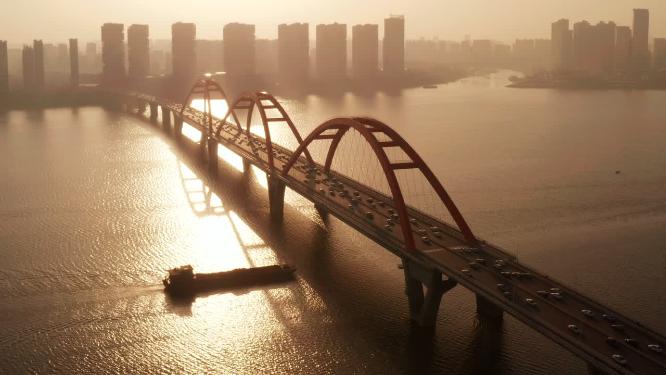 清晨唯美日出下轮船驶过长沙福元路大桥