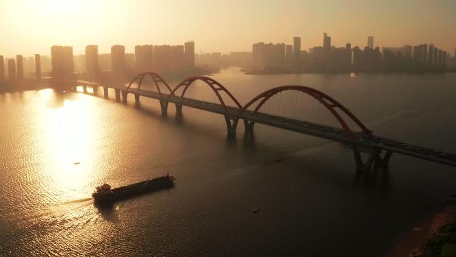 清晨唯美日出下轮船驶过长沙福元路大桥