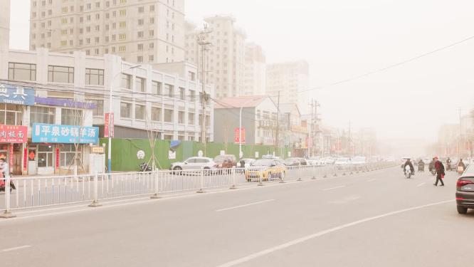 北方沙尘暴天气道路上的汽车与行人