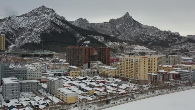 航拍雪后县城高山与高楼