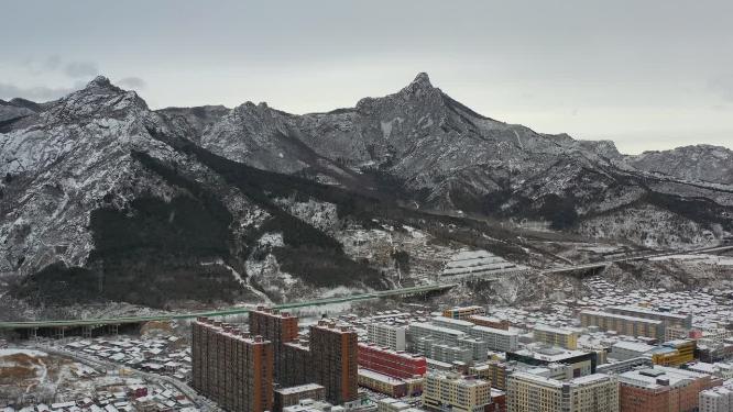 航拍雪后的山峰与城镇城区