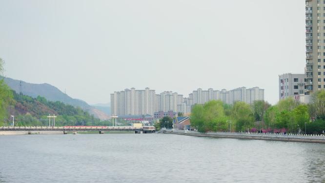 河道旁远处的高楼林立北方城镇
