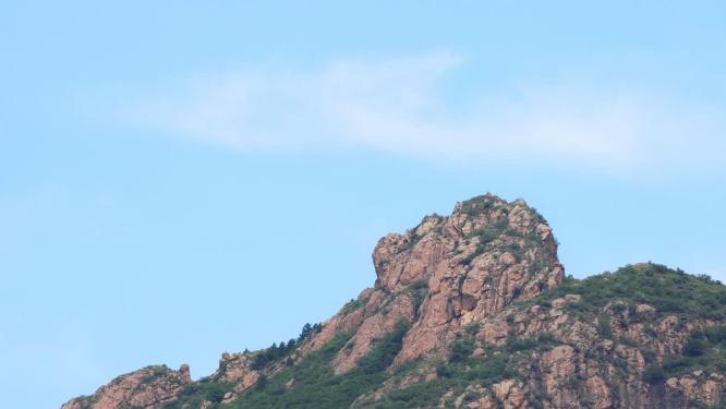 蓝天白云下的山峰巨石