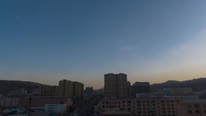 城市日转夜车流灯光升起得月亮